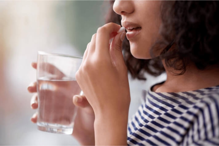 A woman taking dietary supplements